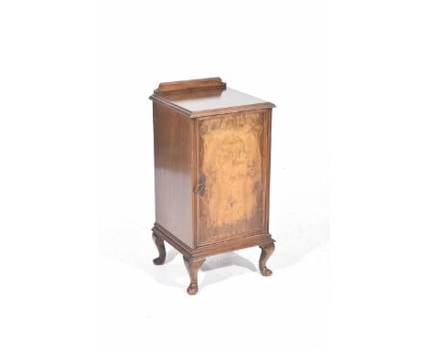 A mid 20th Century walnut pot cupboardThe well figured veneered door enclosing a single shelf, raised on short cabriole legs 