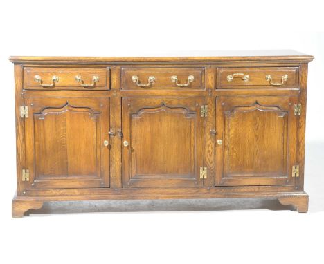 A George III style oak dresser/sideboard, 20th CenturyWith a rectangular moulded top over three frieze drawers each with bras
