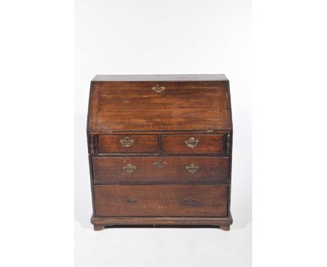 A Georgian oak bureau The fall-front enclosing a compartmentalised and arcaded interior above two short and two long drawers 