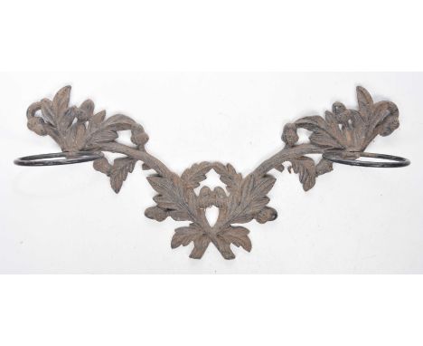 A late Victorian black painted cast iron wall stick standJoined branches of oak leaf and acorns with two twin circular tubula