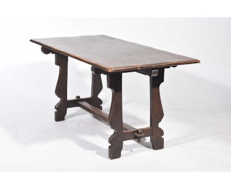 A mid 20th Century elm and oak refectory tableThe rectangular table top supported on shaped bracket supports with a plain cro