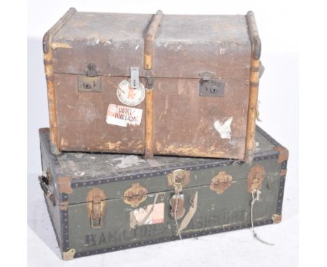 Two vintage travelling trunksThe first a green and metal bound studded case, the hinged cover revealing empty compartment tog