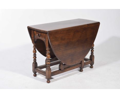 A good quality 17th Century style oval oak drop leaf dining table, 20th CenturyWith a single frieze drawer opposed by a faux 