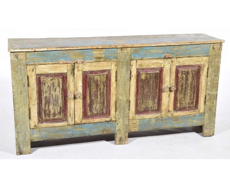 A painted country French style sideboardWith a rectangular two plank top above two pairs of panelled doors each with turned w