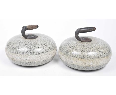 A pair of curling stonesThe granite polished stone of rounded form applied with a bronze and wooden handle, 23cm high. (2)