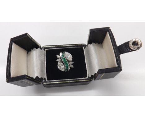 Fine quality platinum emerald and marquise diamond cocktail ring, consisting of a central swirl band of thirteen emeralds, wi