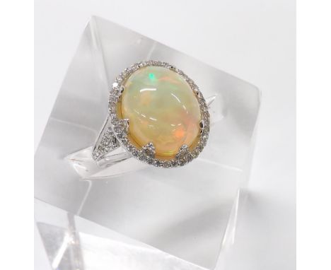 18ct white gold opal and diamond oval set ring, the cabouchon opal 14mm x 13mm in a diamond surround, 5.6gm, ring size P