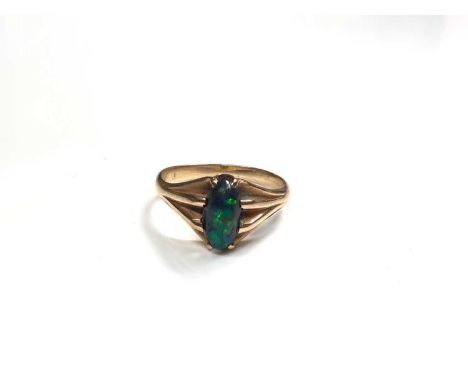 Black opal ring in claw setting with reeded shoulders on yellow metal shank, size LShank is not marked. Weight 3.1 grams 