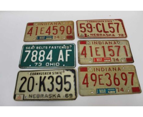 Twelve vintage American car licence plates in wooden box.