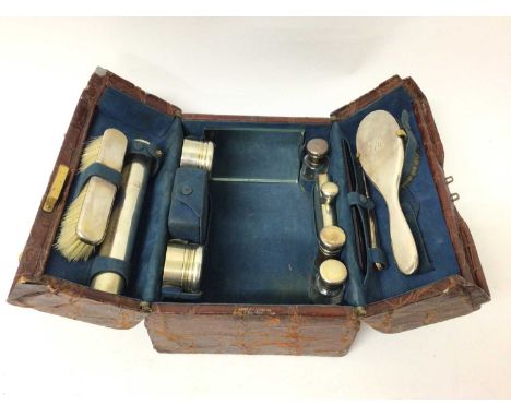 Asprey crocodile leather vanity case containing Asprey silver mounted dressing table items including brushes, scent bottles, 