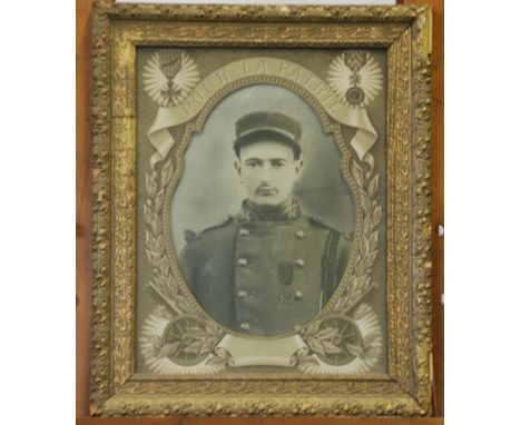 BLACK AND WHITE PHOTOGRAPHIC PORTRAIT  of a young WWI French soldier, in printed mount, inscribed 'Pour La Patrie' and decora