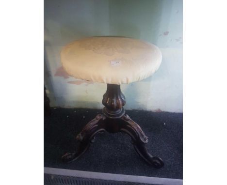 of circular form the upholstered top supported by a carved pillar with three cabriole legs 