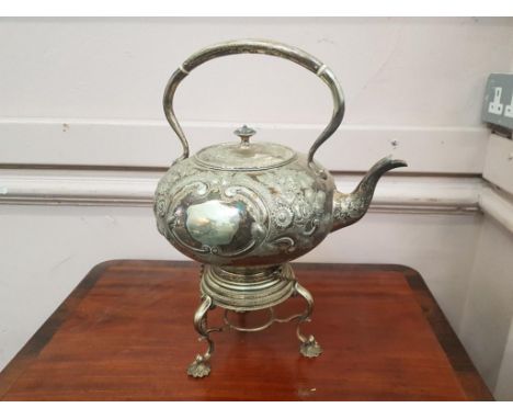 of bulbous form decorated with a chased foliate pattern on original tripod stand, burner missing 