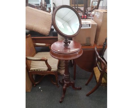 of circular form, the mirror raised above a storage compartment with two hinged lids, all supported by a turned carved pillar
