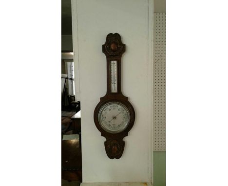 the carved oak case with a long neck supporting a dual scale mercury thermometer above a circular faced aneroid barometer, so