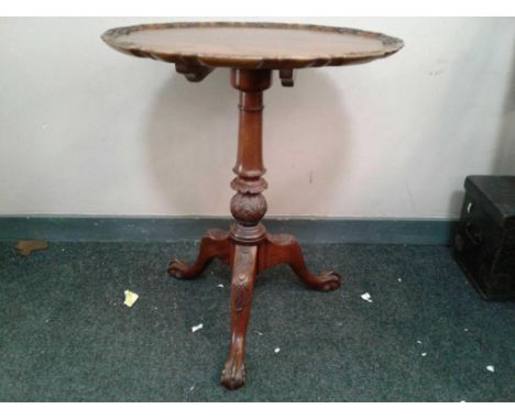 of shaped circular form, the carved cavetto top supported by a turned and carved pillar leading to three cabriole legs with a