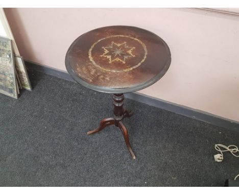 the moulded circular top inlaid with brass and supported by a turned column support leading to a pierced tripod base 