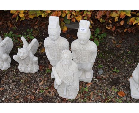 Three concrete garden ornaments in the form of warriors