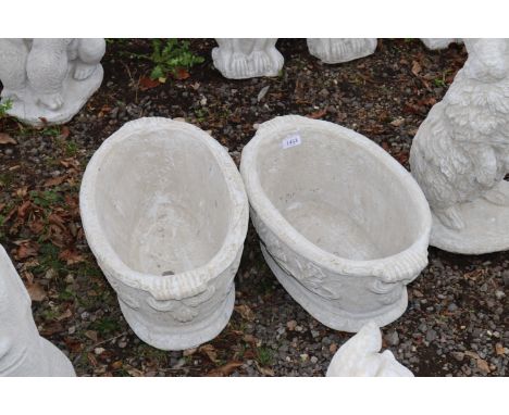 Two concrete garden ornaments in the form of planters