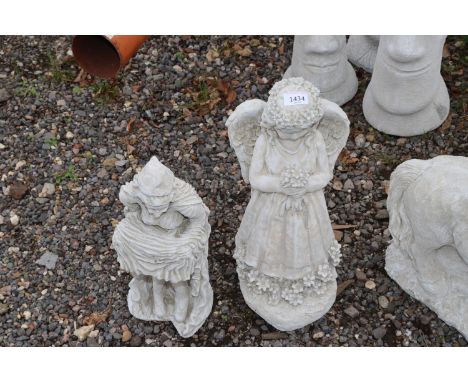 Two concrete garden ornaments in the form of a witch and an angel