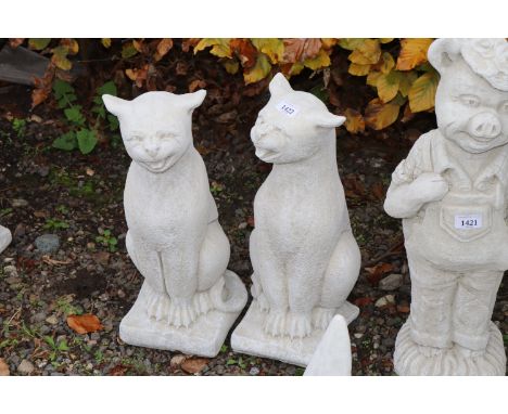 A pair of concrete garden ornaments in the form of cats