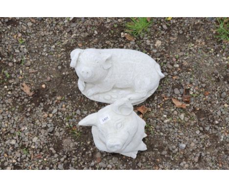 Two concrete garden ornaments in the form of pigs