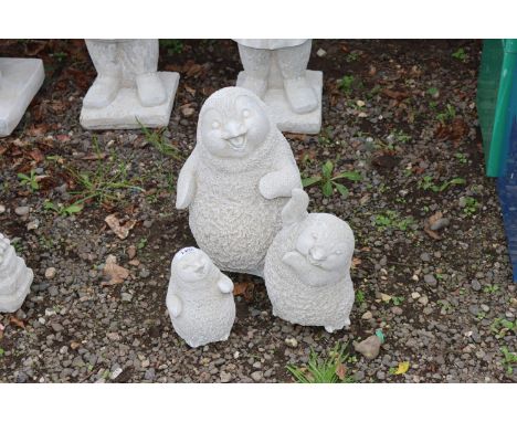 Three concrete garden ornaments in the form of  penguins