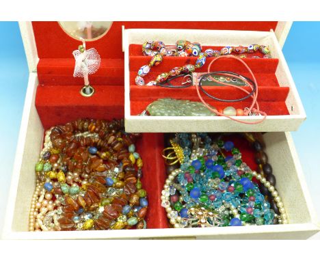 A jewellery box and contents including amber and other bead necklaces and two jade pendants, 1.70kg