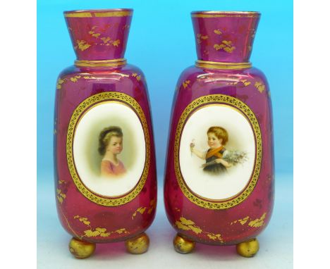 A pair of cranberry and gilt decorated glass vases with enamel portrait panels, one a/f, 18cm, (one slightly larger)