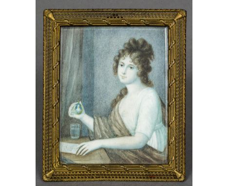 A 19th century miniature portrait on ivoryDepicting a young girl at a writing desk holding a miniature, housed in a pierced b