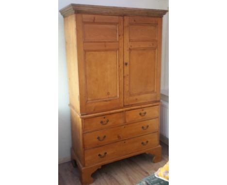 A George III pine linen pressThe top with twin panelled doors enclosing four slides, the base section with an arrangement of 