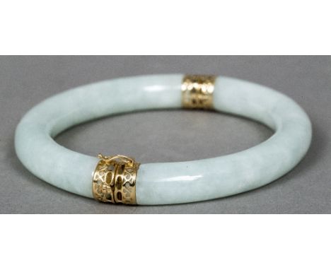 A Chinese 14 K gold mounted jade bangleOf hinged tubular form.  8 cm wide.    CONDITION REPORTS:  Generally in good condition