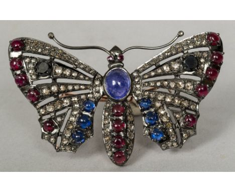 An unmarked white and yellow metal diamond, ruby and sapphire set butterfly brooch8 cm wide.   CONDITION REPORTS:  Generally 