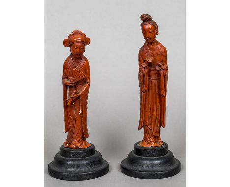 Two Chinese cinnabar lacquer figures of womenOne holding a fan and a scroll, the other with elaborately decorated robes, each