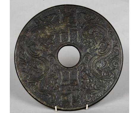 A large Chinese carved green and russet jade bi discCarved with dragons flanking calligraphic text.  30 cm diameter.    CONDI