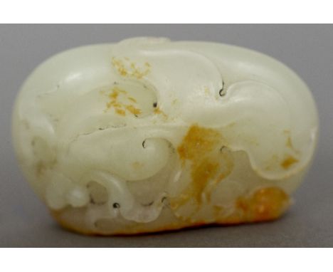 A Chinese carved green and russet jade pebbleWorked to one side with a dragon eyed Wen goldfish.  4 cm wide.    CONDITION REP