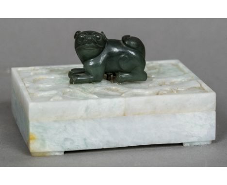 A Chinese carved jade boxOf hinged rectangular form, the lid with foliate decoration and mounted with a dog-of-fo.  12 cm wid