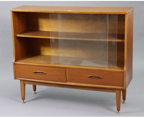 A mid-20th century teak dwarf bookcase with an adjustable shelf enclosed by a pair of glass sliding doors above two short dra