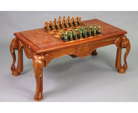 A Sri Lankan carved hardwood low occasional games table, having elephant design to the reversible top, with chessboard to the