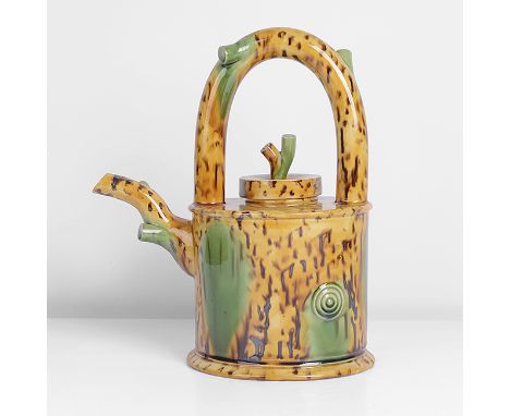 Earthenware, vivid yellow glaze with running brown speckles and green splashes, mounted with a 'branch' handle, spout and fin