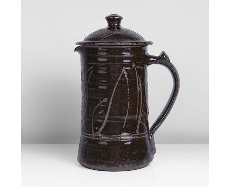 Stoneware, rich dark brown glaze with incised cross and dot design revealing the unglazed body beneath, impressed MC and Wenf
