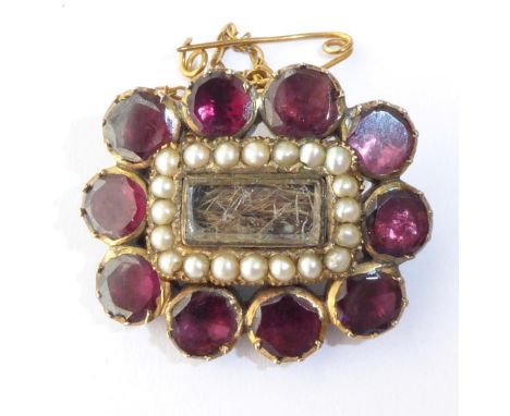 A Georgian Garnet and Seed Pearl Hairwork Mourning Brooch, measures 2.5cm by 1.5cm .  Gross weight 6.5 grams. 