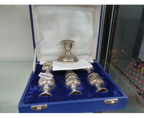 A SILVER CANDLESTICK TOGETHER WITH WHITE METAL EGG CUPS