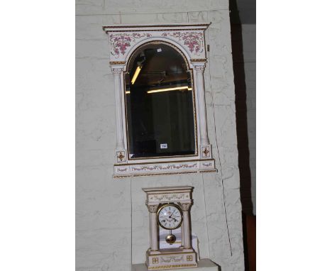 White and gilt four pillar mantel clock with floral swags and matching mirror.
