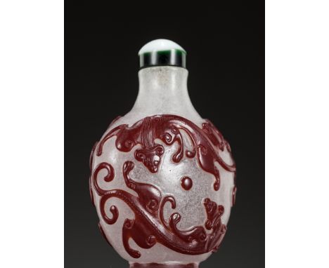 A RUBY-RED OVERLAY SNOWFLAKE GLASS 'CHILONG' SNUFF BOTTLE, 19TH CENTURYChina. The ovoid body supported on a short foot and ri