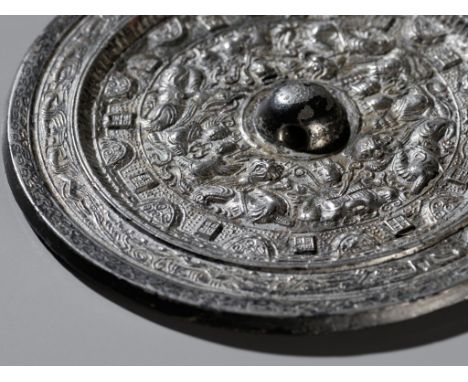 A SILVERED BRONZE 'DEITIES AND BEASTS' MIRROR, HAN DYNASTYChina, 206 BC to 220 AD. Of circular form, the central knob is enci
