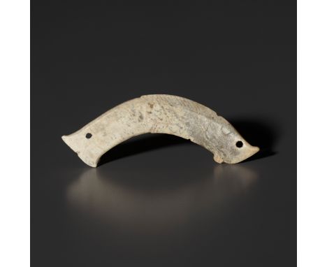 A PALE CELADON JADE 'FISH' PENDANT, LATE SHANG TO WESTERN ZHOU DYNASTYChina, 1300-771 BC. Of flattened form, carved as a curv