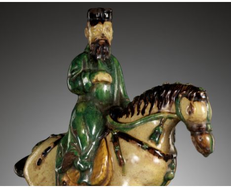 A SANCAI GLAZED EQUESTRIAN-FORM ROOF TILE, MING DYNASTYChina, 1368-1644. A well modeled dignitary depicted on an arched tile 