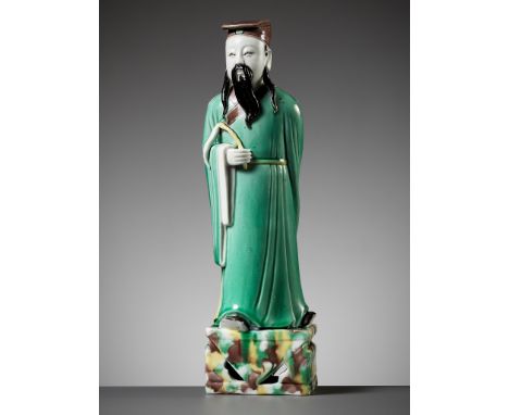 A GREEN, YELLOW AND AUBERGINE-GLAZED BISCUIT FIGURE OF A DAOIST IMMORTAL, KANGXI PERIODChina, 1662-1722. Molded as Lue Dongbi