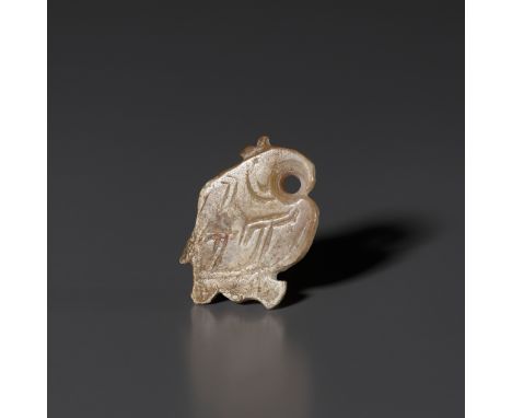 A PALE CELADON AND RUSSET JADE 'BIRD' PENDANT, LATE SHANG DYNASTYChina, 1300-1050 BC. The flat stone worked in the form of a 